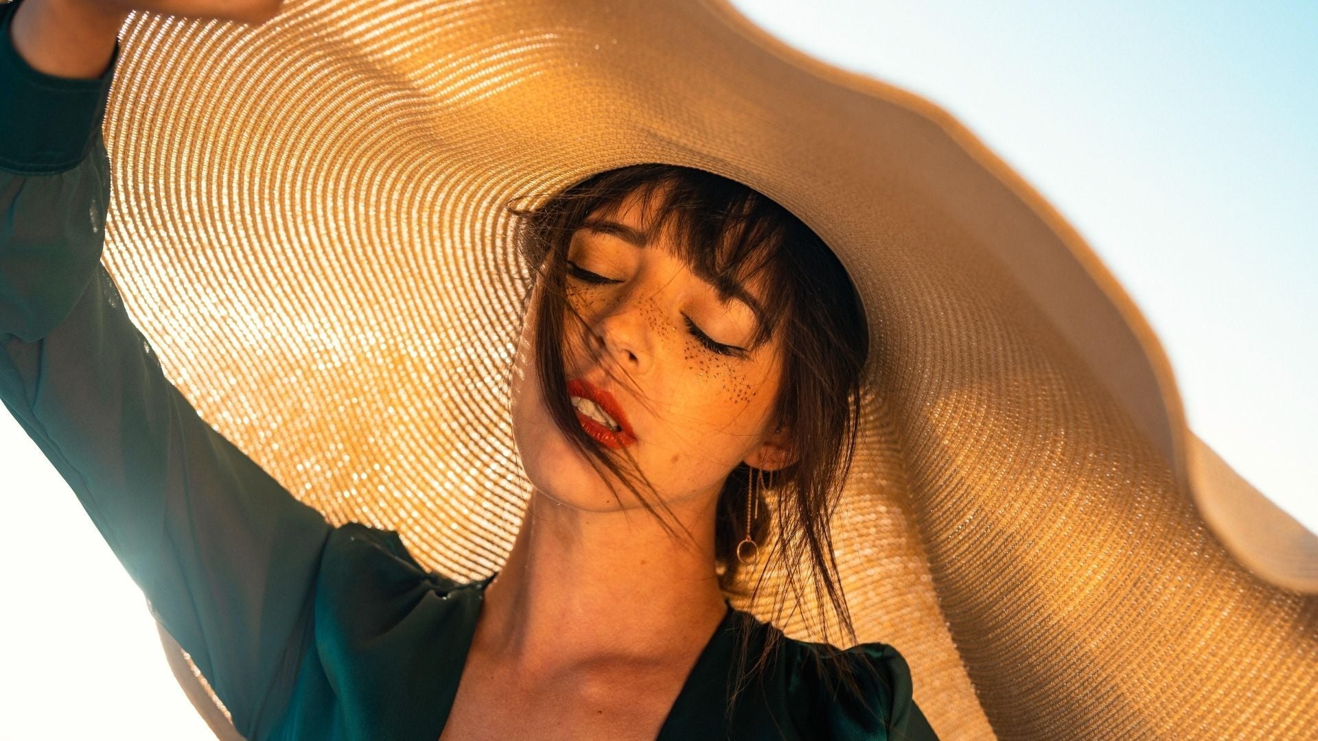 Woman shields herself from the sun and getting melanoma under a big hat