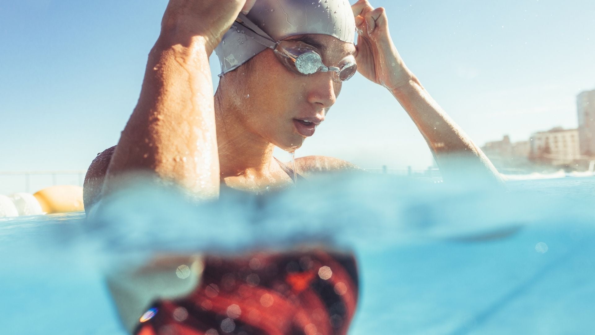 Women putting on goggles and waterproof sunscreen for swimming in the ocean