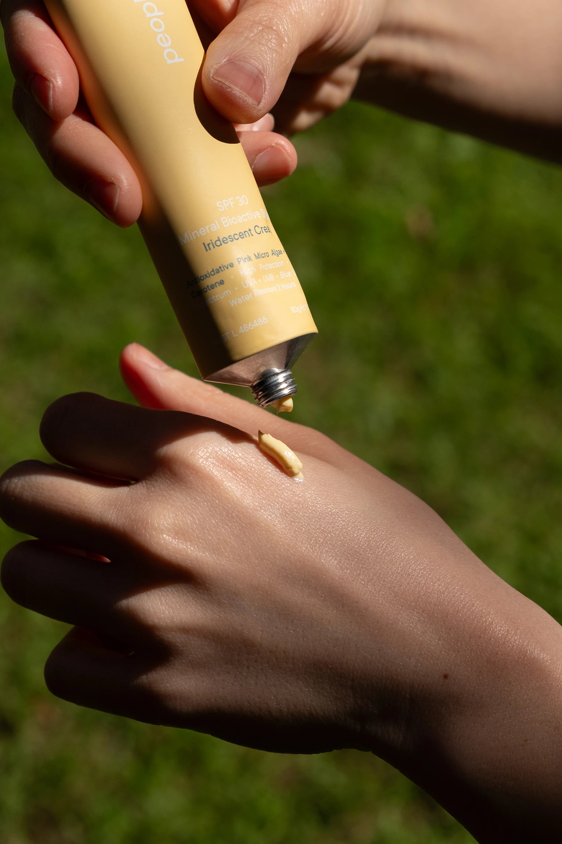 Person applying sunscreen to their hand outdoor