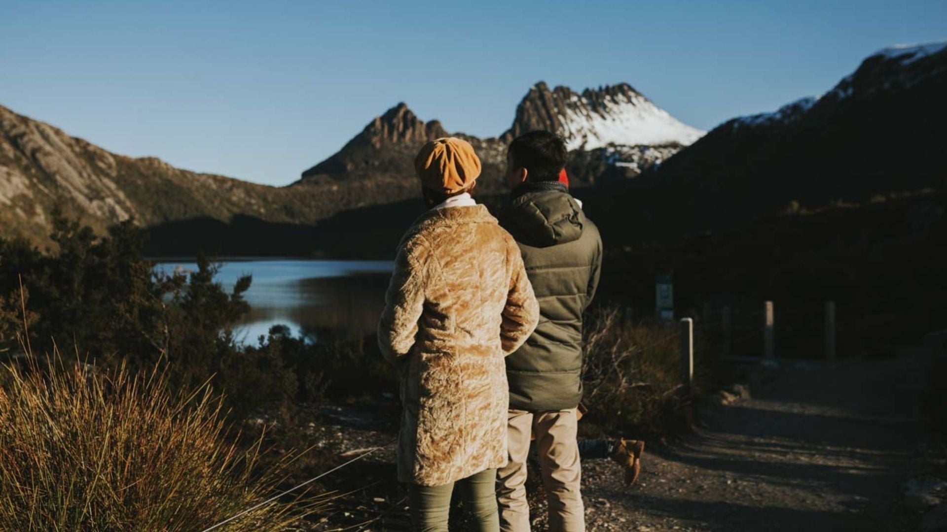 A woman and a man looking at the view of Cradle Mountain in winter