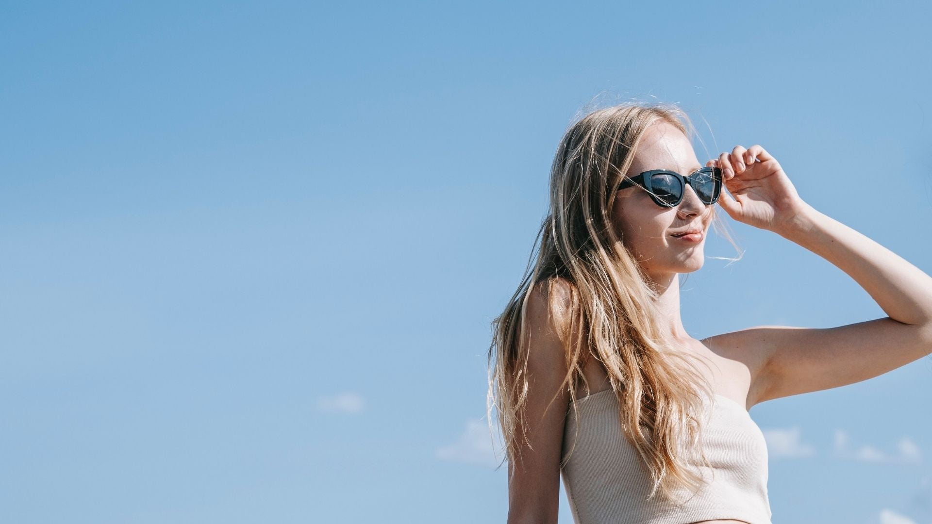 Blonde woman wearing designer sunglasses outside